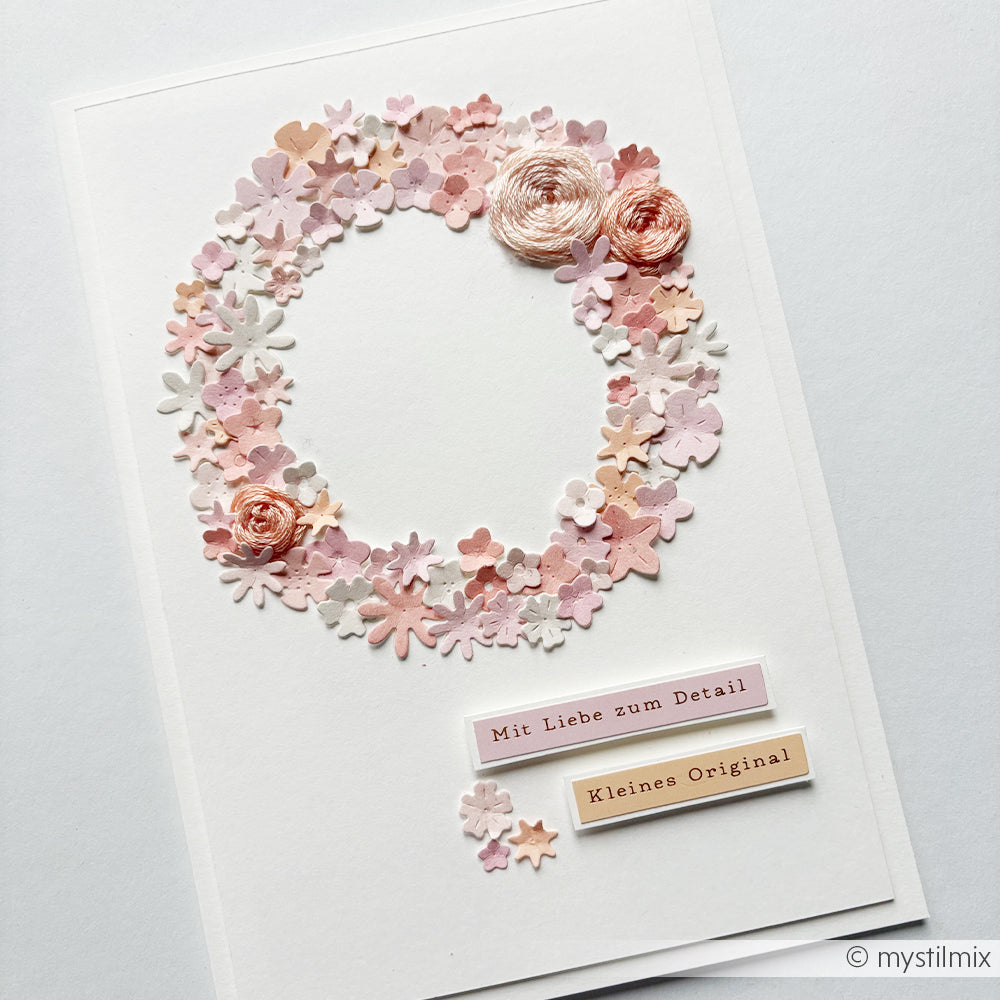 Handgefertigte Karte mit einem rosa Blumenkranz und deutschen Beschriftungen, verziert mit zwei rosa Blüten, die mit der Stanzform „Streublümchen“ von Alexandra Renke oben rechts ausgestanzt wurden. Hergestellt aus hochwertigen Designpapieren von Alexandra Renke für ein elegantes Finish.