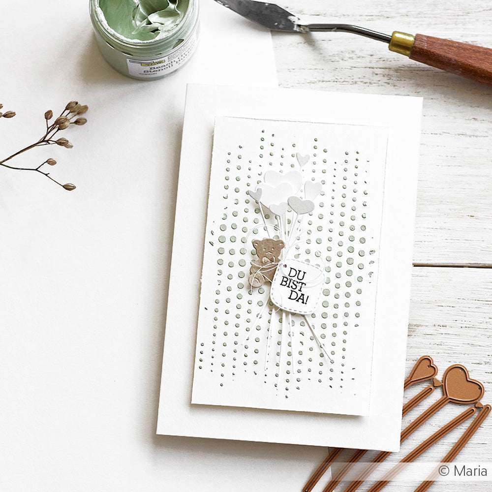 Handgefertigte Karte mit weißen Blumen, hergestellt mit der Motivstanze Herzchen am Stiel von Alexandra Renke aus dem Dies-Set, mit dem Text DU BIST DA! auf gepunktetem Hintergrund, auf einem weißen Tisch.