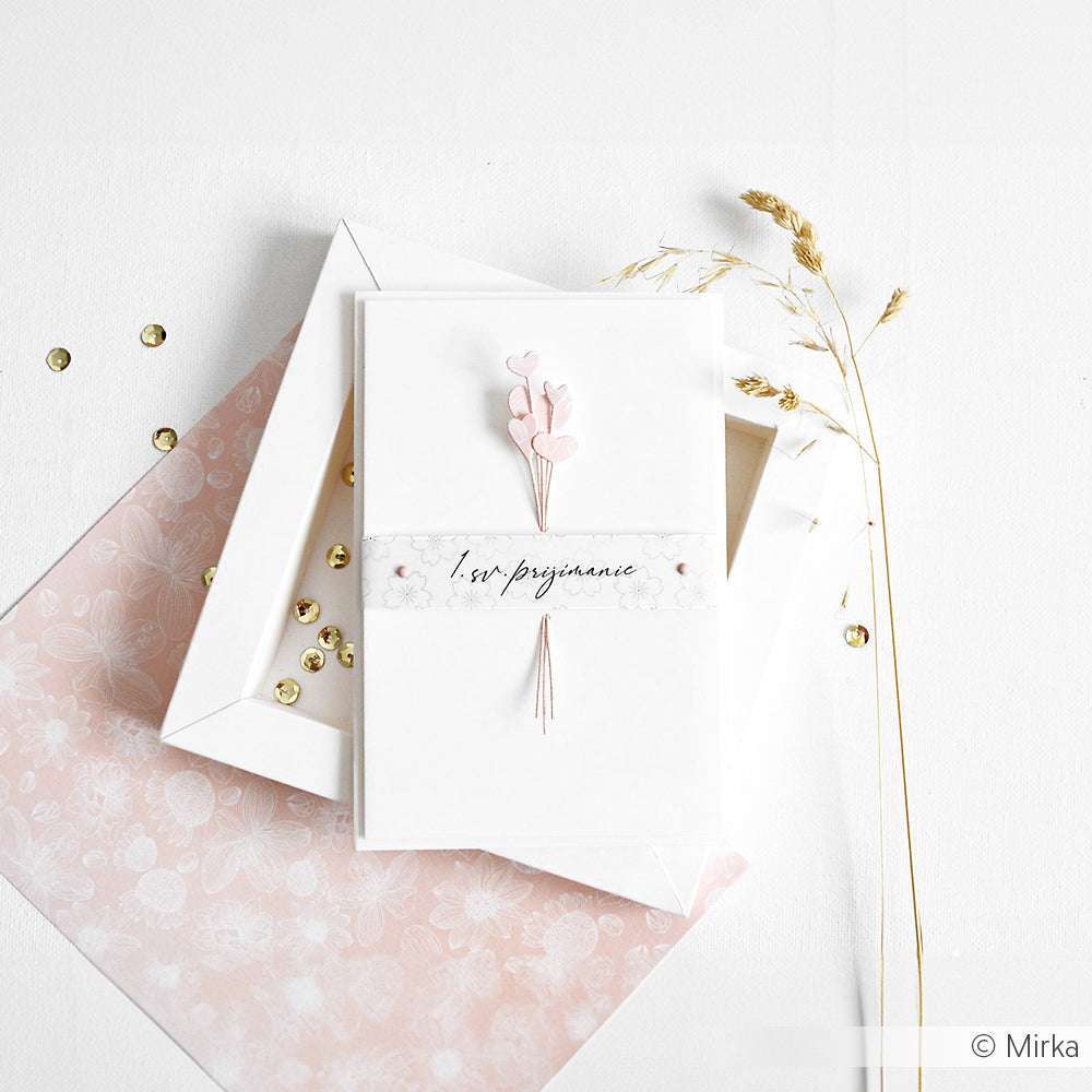 Eine handgefertigte Karte von Alexandra Renke mit "Bon Voyage"-Text, rosa Akzenten und zarten Trockenblumen, hergestellt mit Designpapieren und einer Motivstanze Herzchen, präsentiert auf einer weißen Schachtel und Blumenpapier.