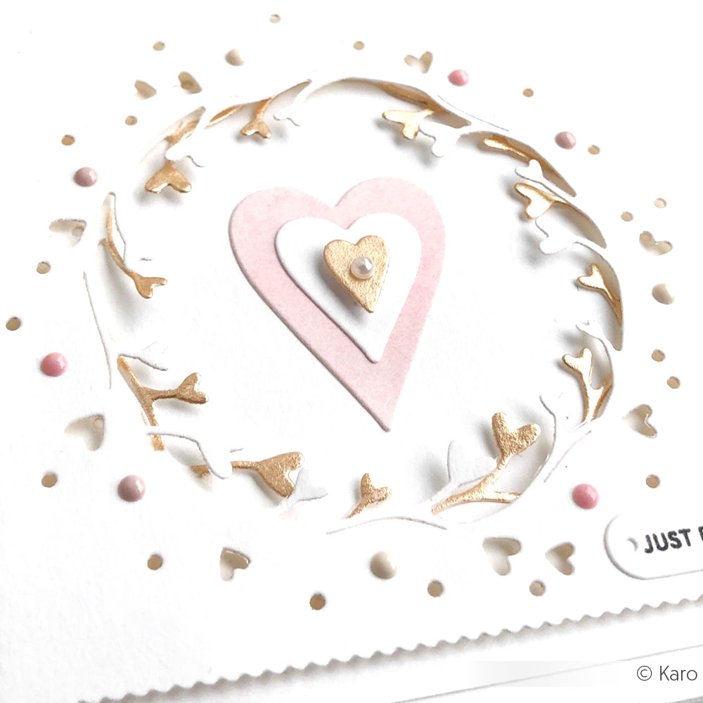 Handgemachte Karte von Alexandra Renke mit geschichteten rosa und goldenen Herzen, goldenen Zweigen und rosa Punkten auf weißem Designpapier. Mit Akzenten, die mit dem Herz-Tag Set Dies erstellt wurden.