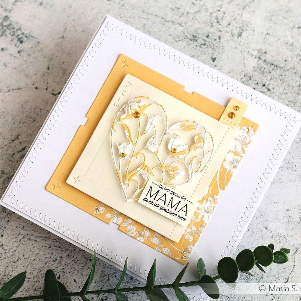 Handgefertigte Karte mit geschichteten Quadraten und einem ausgeschnittenen Blumenherz mit der Motivstanze Gefülltes Blumenherz von Alexandra Renke sowie einer "Mama"-Notiz auf strukturiertem Papier - perfekt für Fans von Stanzen für Papierbasteln.