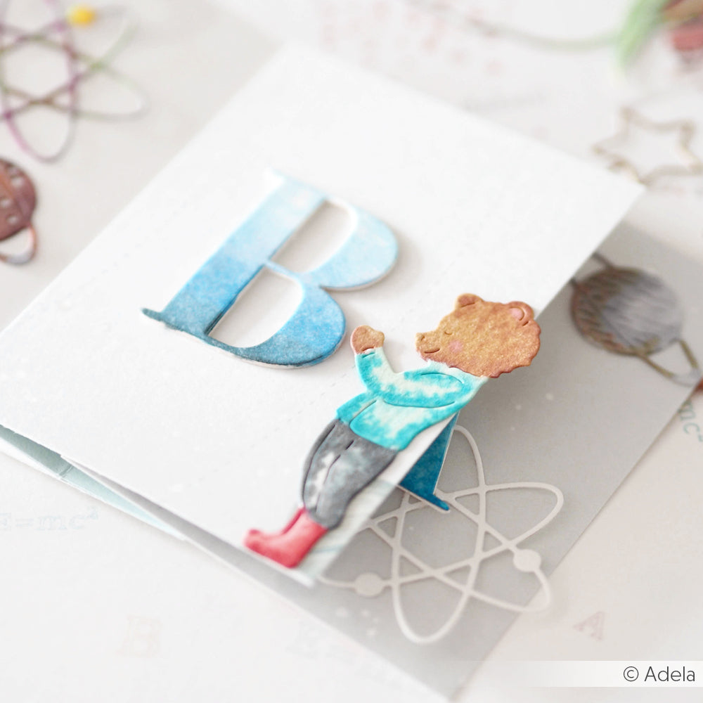 Eine Karte mit einem großen blauen Buchstaben B und einem niedlichen Bären in roten Stiefeln, gestaltet mit der Alexandra Renke Motivstanze Bär mit Schultüte - perfekt für Fans von Stanzsystemen.