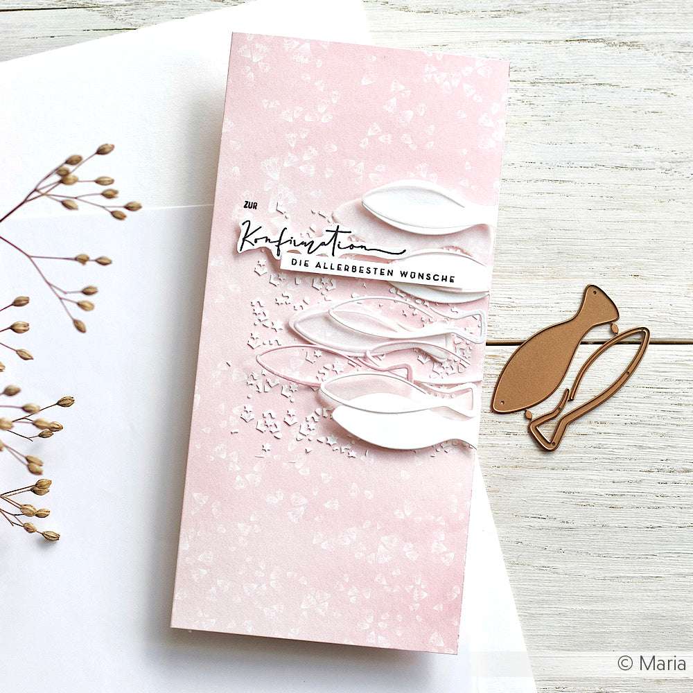 Eine rosafarbene Grußkarte von Alexandra Renke mit weißen Fischausschnitten, hergestellt mit der Motivstanze Fisch und Designpapieren, zeigt deutschen Text auf einer weißen Fläche mit einem Zweig und einer fischförmigen Stanze.