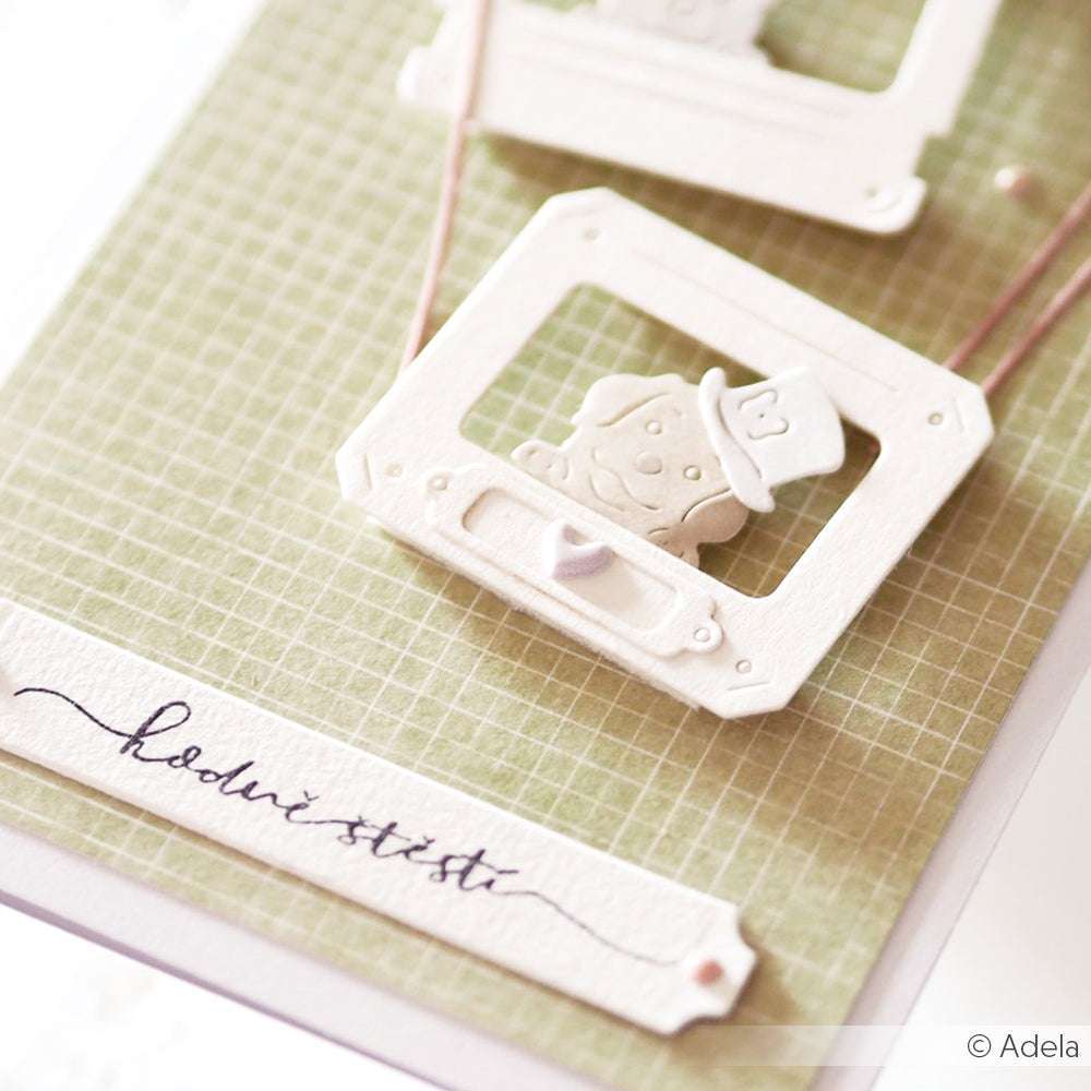 Weißer Papierausschnitt eines Fernsehers mit Zeichen auf grünem Gitterkarton, hergestellt mit Alexandra Renke Stanzformen und Stanzsystemen, mit handgeschriebenem Text darunter.