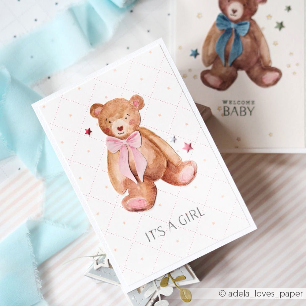 Eine Karte mit einem aquarellierten Teddybär, einer rosa Schleife und dem Text "ITS A GIRL!", die mit der Motivstanze Herzliches Bärchen von Alexandra Renke erstellt wurde, neben einer blauen Karte mit dem Thema Baby.