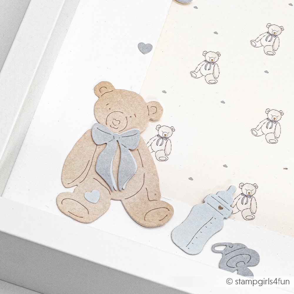 Papierausschnitt eines Teddybären, Babyflasche und Schnuller neben den Designpapieren mit Teddybär-Muster von Alexandra Renke in einem weißen Rahmen - ideal zum Basteln mit Motivstanze Bärchen oder DieCut Systemen.