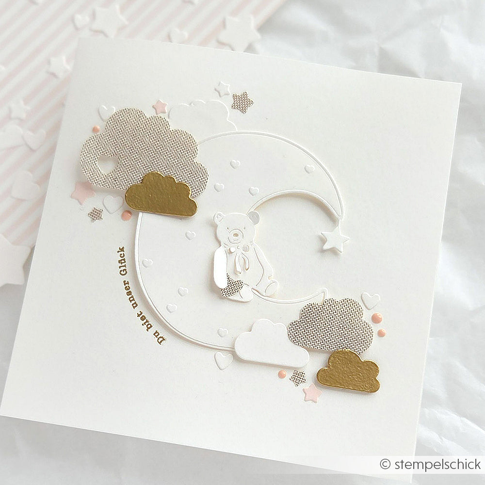 Handgefertigte Karte von Alexandra Renke mit einem Teddybär auf einer Mondsichel mit Wolken, Sternen und Herzen - hergestellt mit Designpapieren und DieCut Systemen für charmante Details.