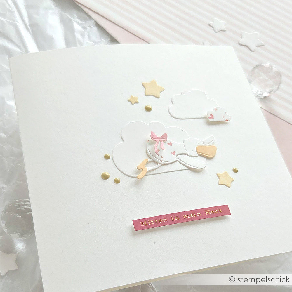 Handgefertigte Karte von Alexandra Renke mit Designpapier, einem Storch, Wolken, Sternen, goldenen Punkten und einem rosafarbenen Aufkleber mit der Aufschrift "Mitten in mein Herz".