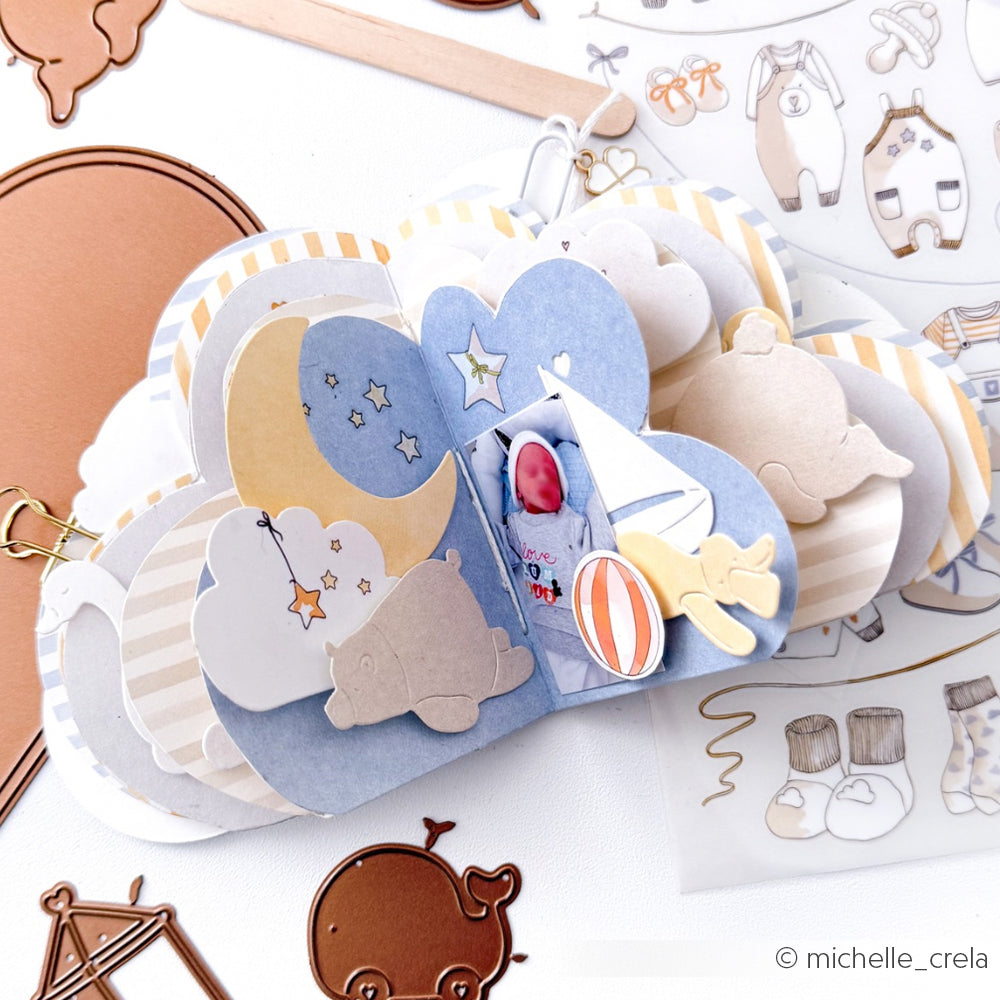Farbenfrohes, wolkenförmiges Scrapbook mit Aufklebern und Ausschnitten zum Thema Baby - Mond, Sterne, Spielzeug und bezaubernde Details - hergestellt mit Alexandra Renke Motivstanze Gute-Nacht-Ente.