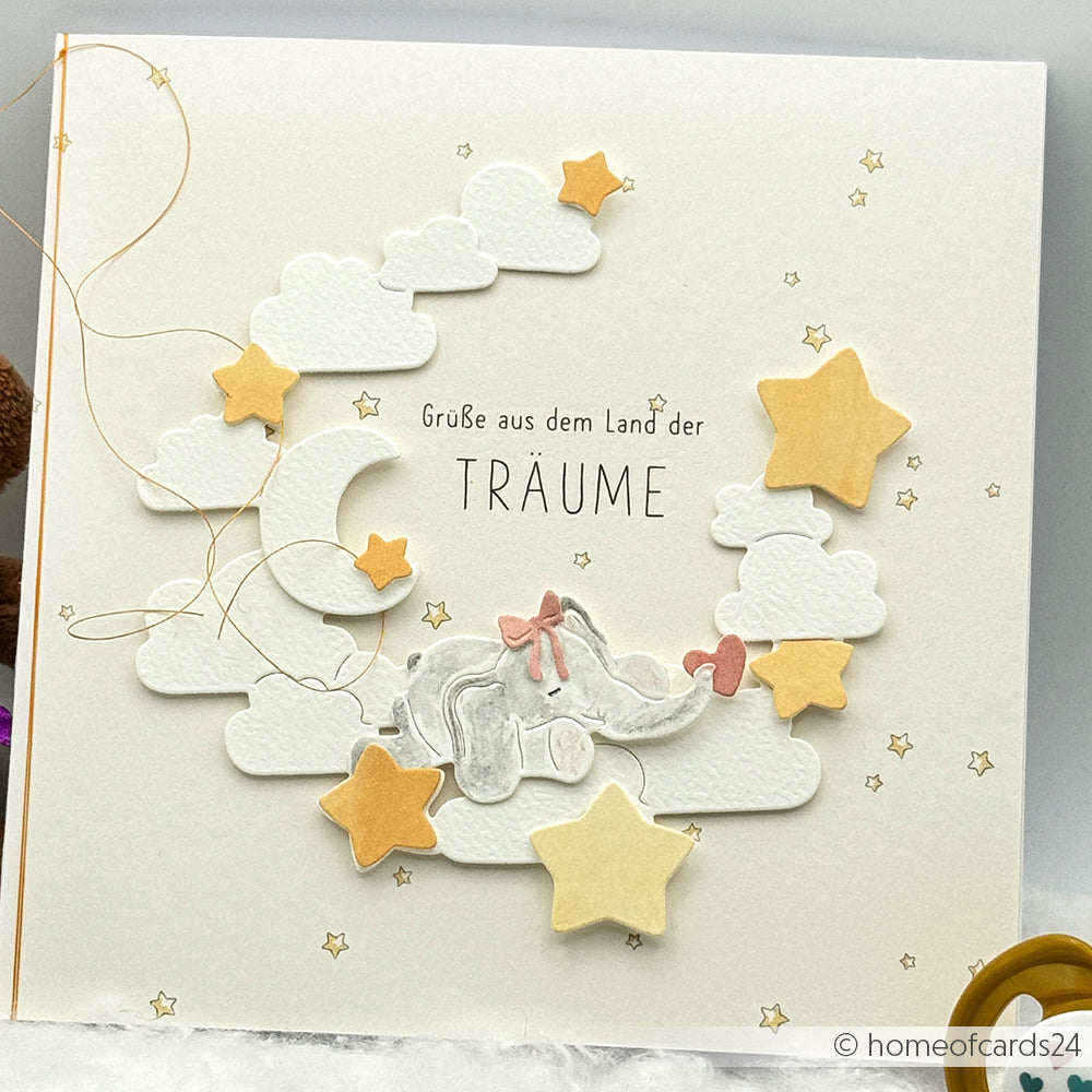 Bezaubernde Alexandra Renke Grußkarte mit einem schlafenden Elefanten auf Wolken, Sternen und Mond mit dem Text "Grüße aus dem Land der Träume" - hergestellt mit Motivstanze Schlafgefährten und hochwertigen Designpapieren.