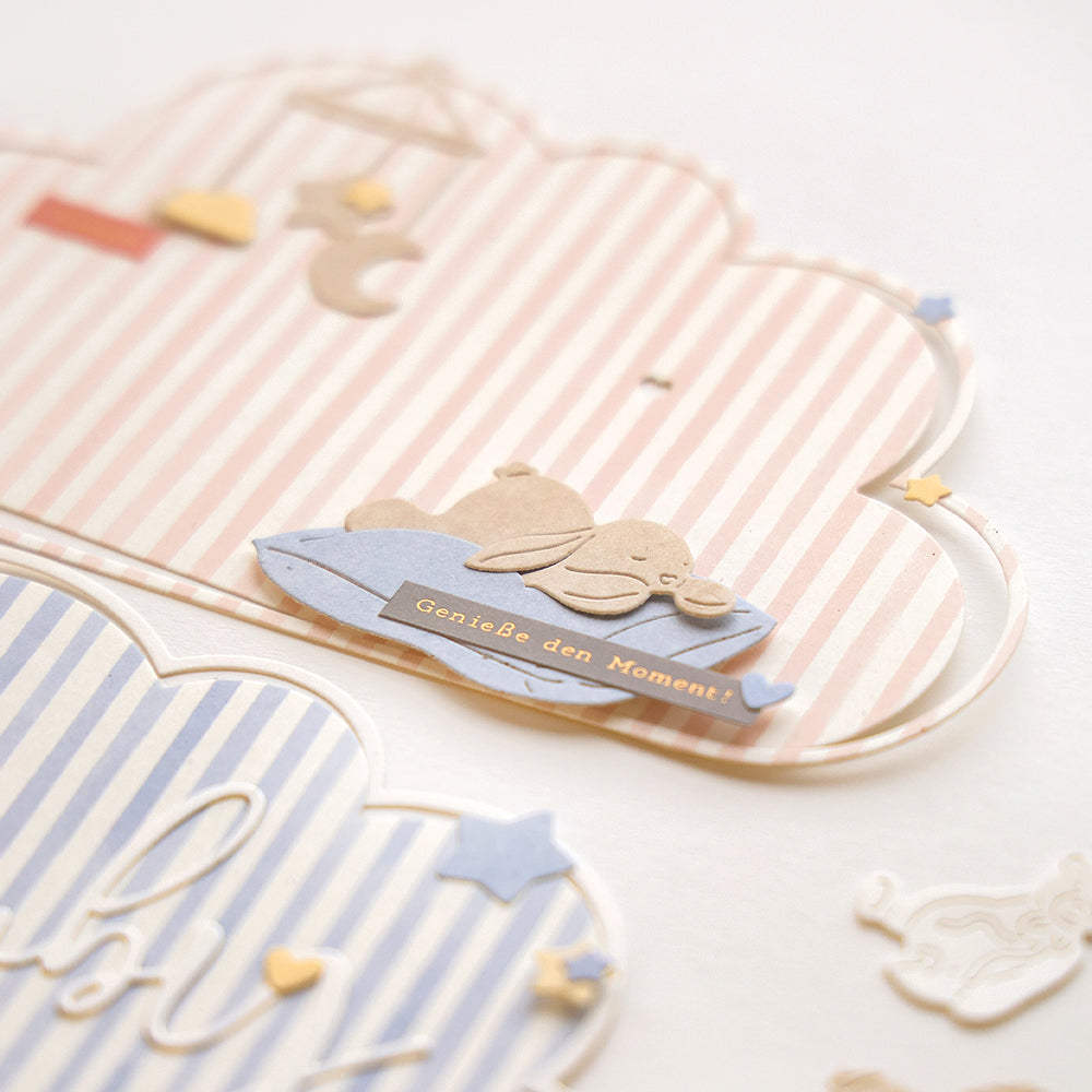 Nahaufnahme von pastellfarbenen wolkenförmigen Karten, die mit Alexandra Renke Designpapier und der Stanze "Müdes Häschen" hergestellt wurden, mit einem niedlichen Hasen und dem Text "Genieße den Moment!".