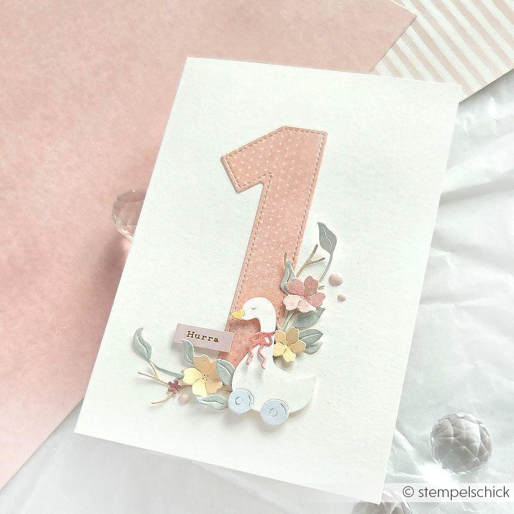 Grußkarte von Alexandra Renke mit einer großen rosafarbenen Zahl 1, einer Ente auf Rädern, Blumen und "Hurra" - gestaltet mit Motivstanze und lebendigen Designpapieren für einen charmanten Look.