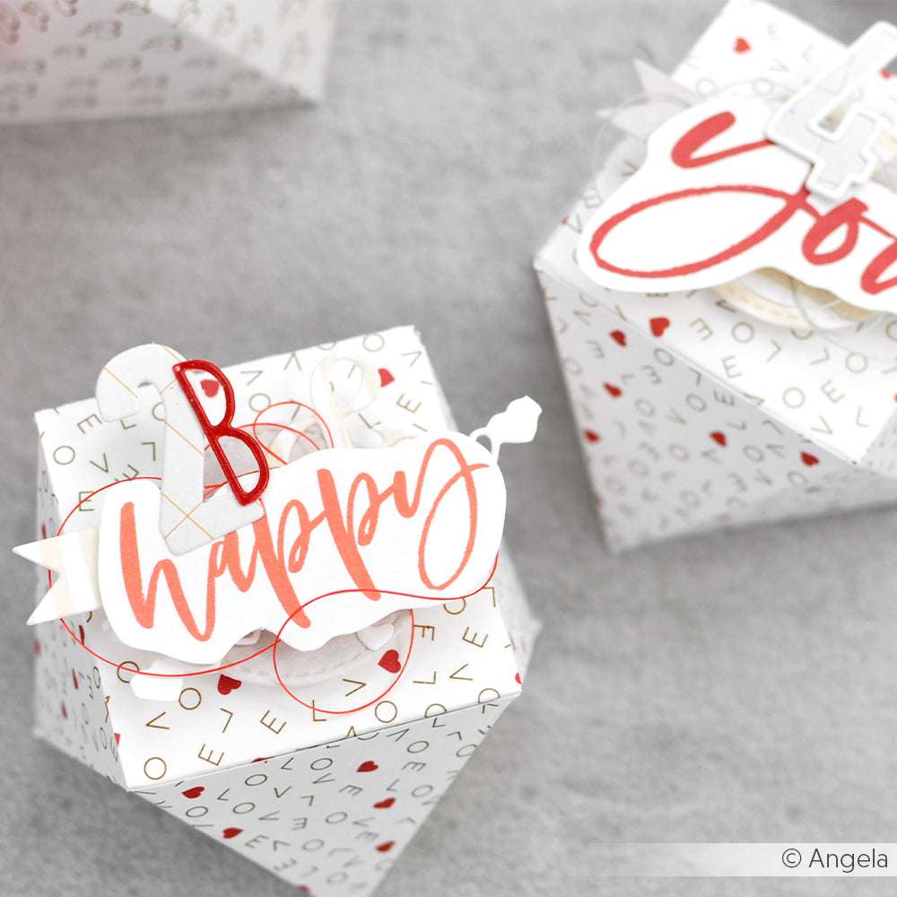 Weiße Geschenkschachteln von Alexandra Renke mit roten und goldenen "Happy"- und "You"-Verzierungen, mit Zahlen und weihnachtlichen Motiven, die mit Designpapieren und dem Motivstanze Sans Serif Alphabet erstellt wurden, für einen einzigartigen, personalisierten Look.