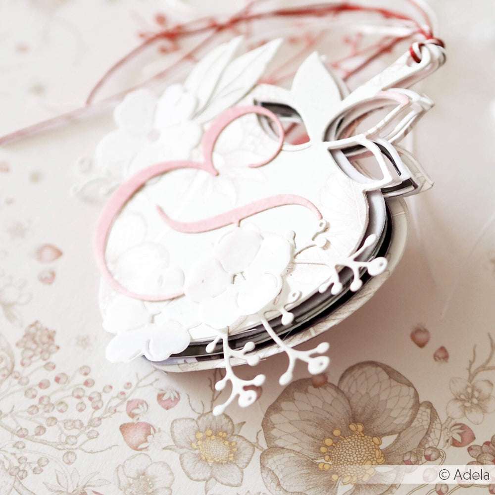 Eleganter, floraler Geschenkanhänger von Alexandra Renke aus hochwertigem Designpapier mit zarten Details in Weiß, Rosa und Silber auf einem pastellfarbenen Blumenhintergrund.