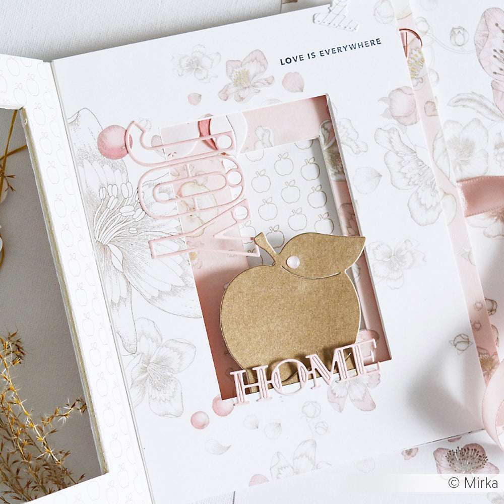 Auf einer Blumenkarte von Alexandra Renke ist ein ausgeschnittener Apfel mit Dies, HOME in Motivstanze Konturbuchstaben und LOVE IS EVERYWHERE oben rechts aufgedruckt.