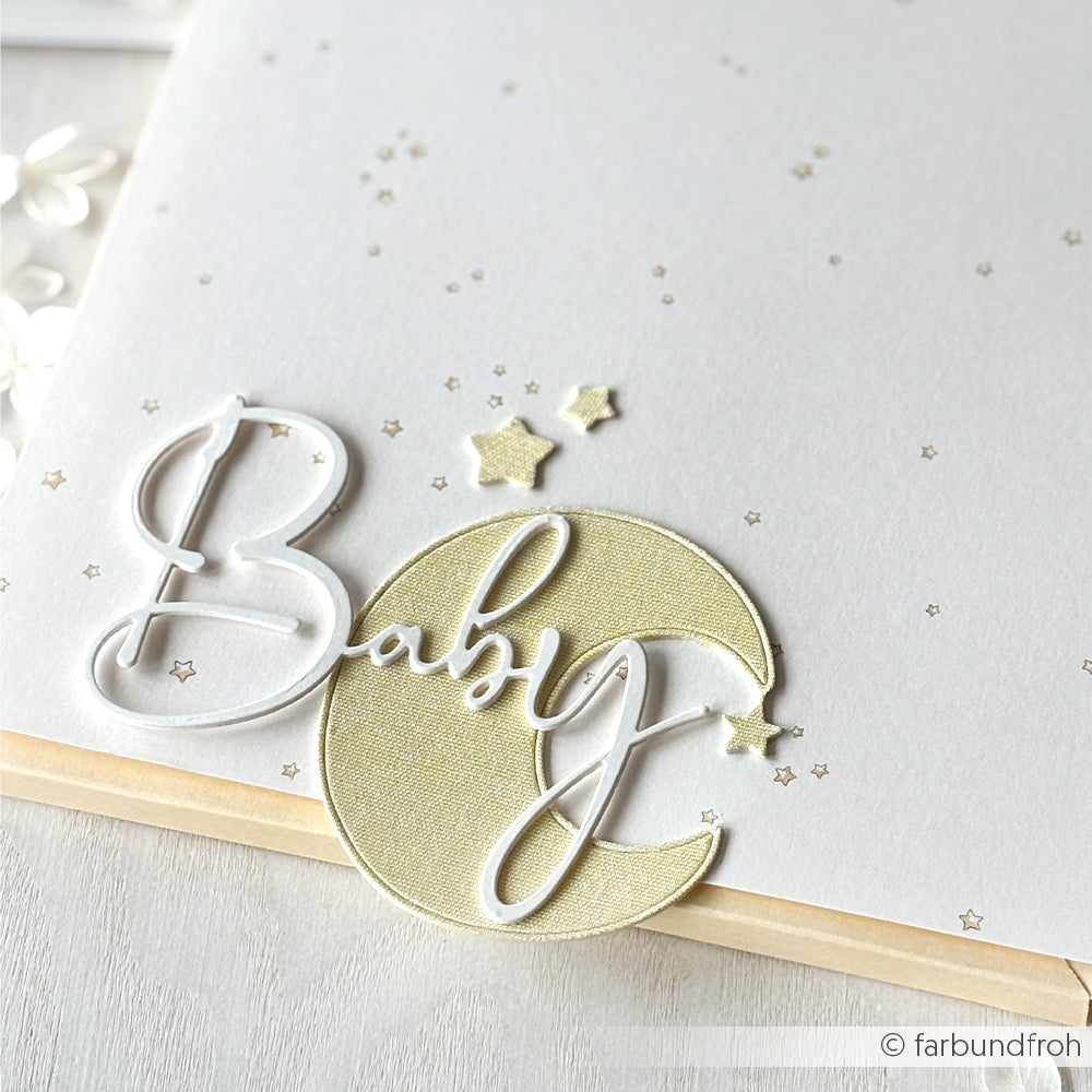 Weiße Karte mit dem Text "Baby", einer goldenen Mondsichel und kleinen Sternen auf einem weichen, neutralen Hintergrund. Perfekt zum Basteln mit Alexandra Renke Designpapieren oder zum Hinzufügen von Details mit Ihren bevorzugten DieCut Systemen oder Motivstanze.