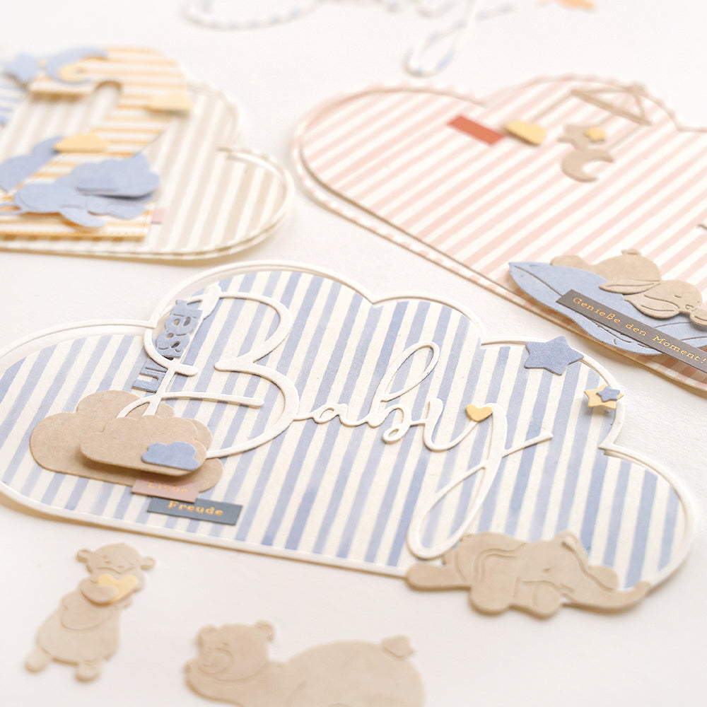 Wolkenförmige Babykarten mit pastellfarbenen Streifen, Tierausschnitten von Alexandra Renke und geschichteten Papierverzierungen auf Weiß, mit Details der Lebendigen Typo Baby für eine besonders charmante Note.