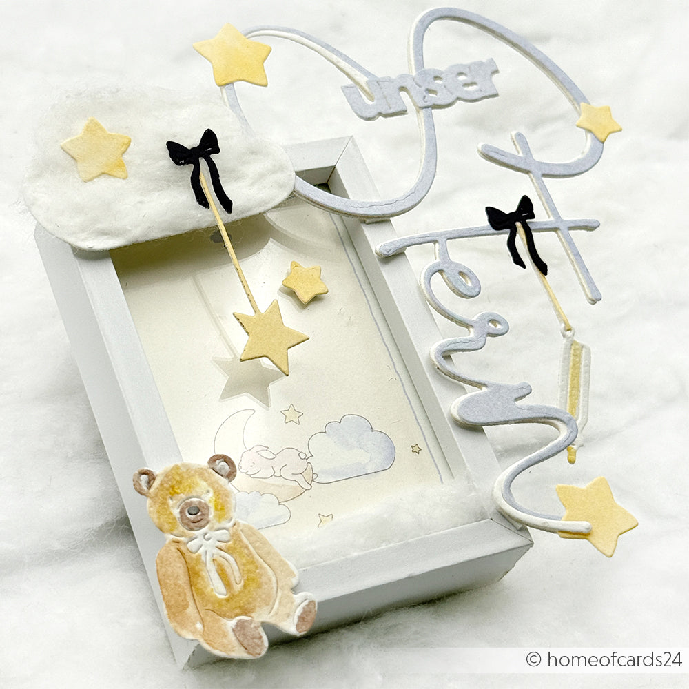 Eine dekorative Schattenbox von Alexandra Renke mit Sternen, einem Teddybär und "unserem Stern", die mit Designpapier und einem Motivstanzer für bezaubernde Wolken- und Mondakzente hergestellt wurde.