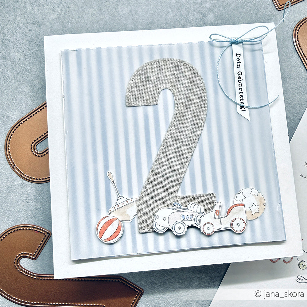 Geburtstagskarte von Alexandra Renke mit einer großen Stoffnummer 2 aus Motivstanze Zahlen Dies, verspielten Spielzeugillustrationen und einem "Dein Geburtstag!"-Tag.