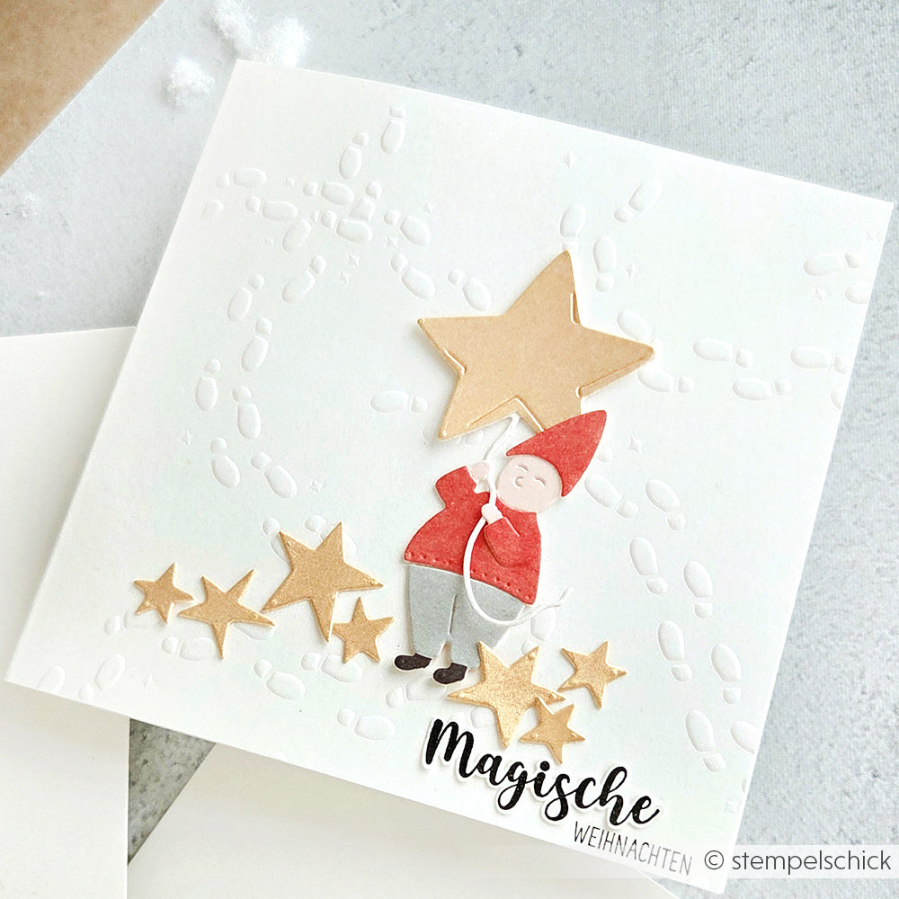 Handgefertigte Weihnachtskarte von Alexandra Renke, hergestellt mit Motivstanze Wichtel Sternzauber. Mit einem Wichtel, der einen goldenen Stern hält, umgeben von kleinen Sternen und geprägten Schneeflocken - perfekt für zauberhafte Weihnachtsgrüße!.