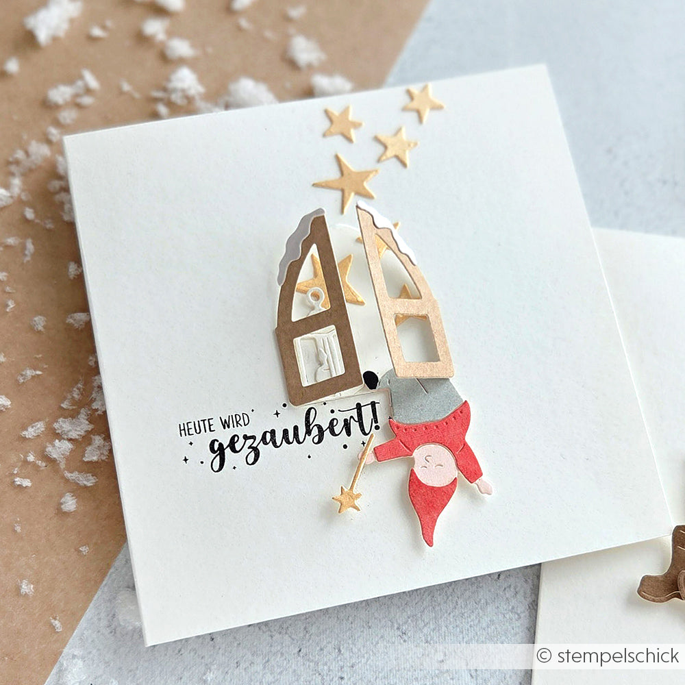 Handgefertigte Karte von Alexandra Renke mit einem Gnom, der kopfüber aus einem offenen Fenster hängt, hergestellt mit der Motivstanze Kleines Fenster, verziert mit goldenen Sternen und dem Text "Heute wird gezaubert!".