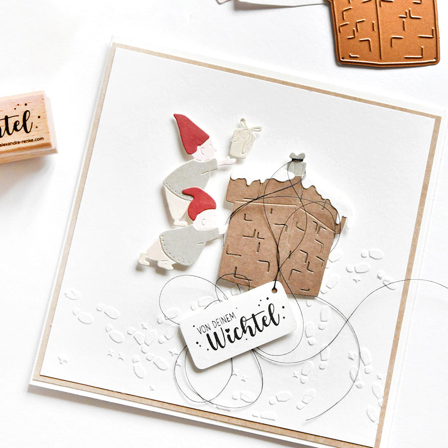 Eine handgefertigte Karte mit der Motivstanze Kleiner Wichtel-Kamin von Alexandra Renke auf 200g Designpapier, mit Wichtelausschnitten, einem braunen Haus und der Aufschrift "Von Deinem Wichtel".