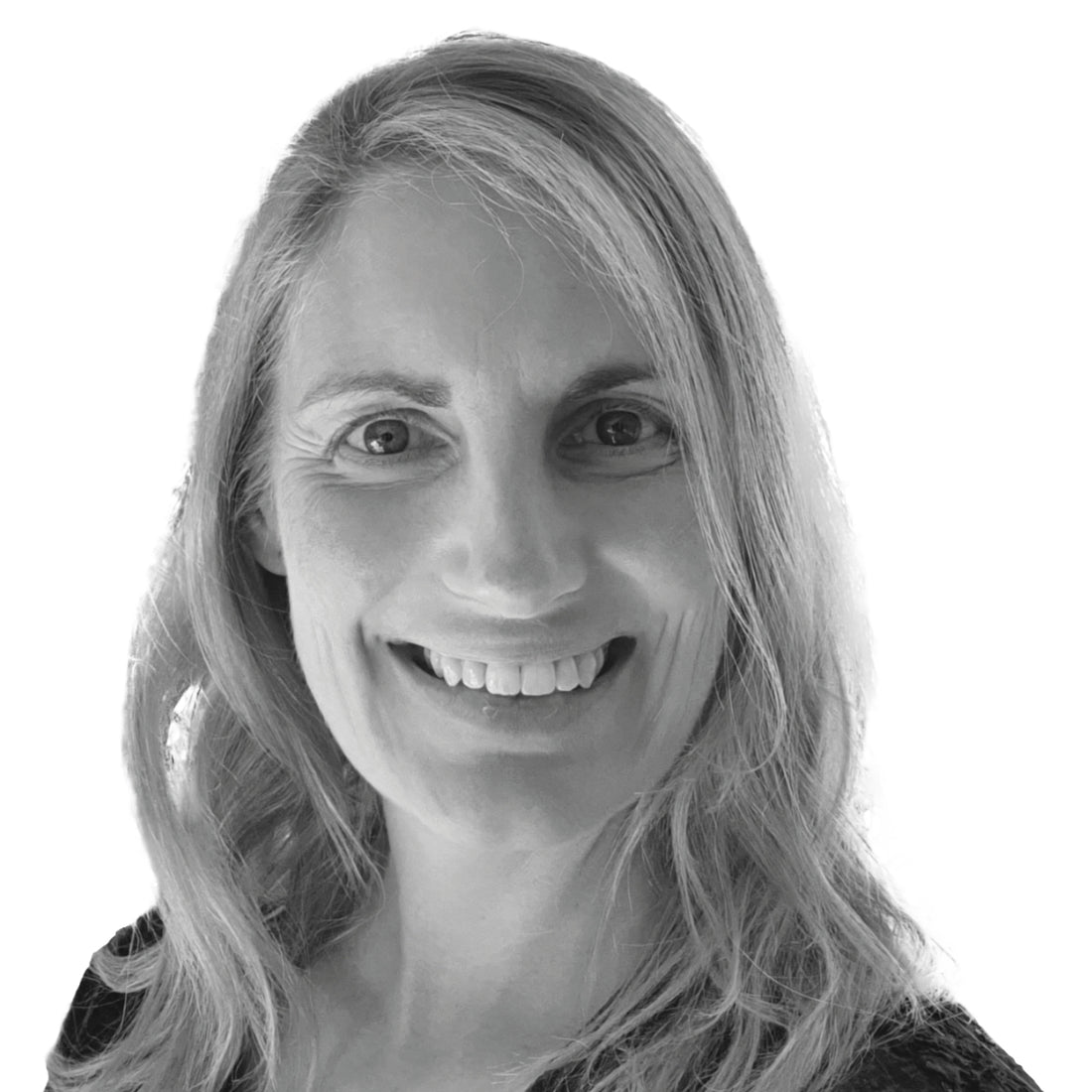 Lächelnde Frau mit langem, gewelltem Haar, die vor einem weißen Hintergrund in die Kamera schaut.