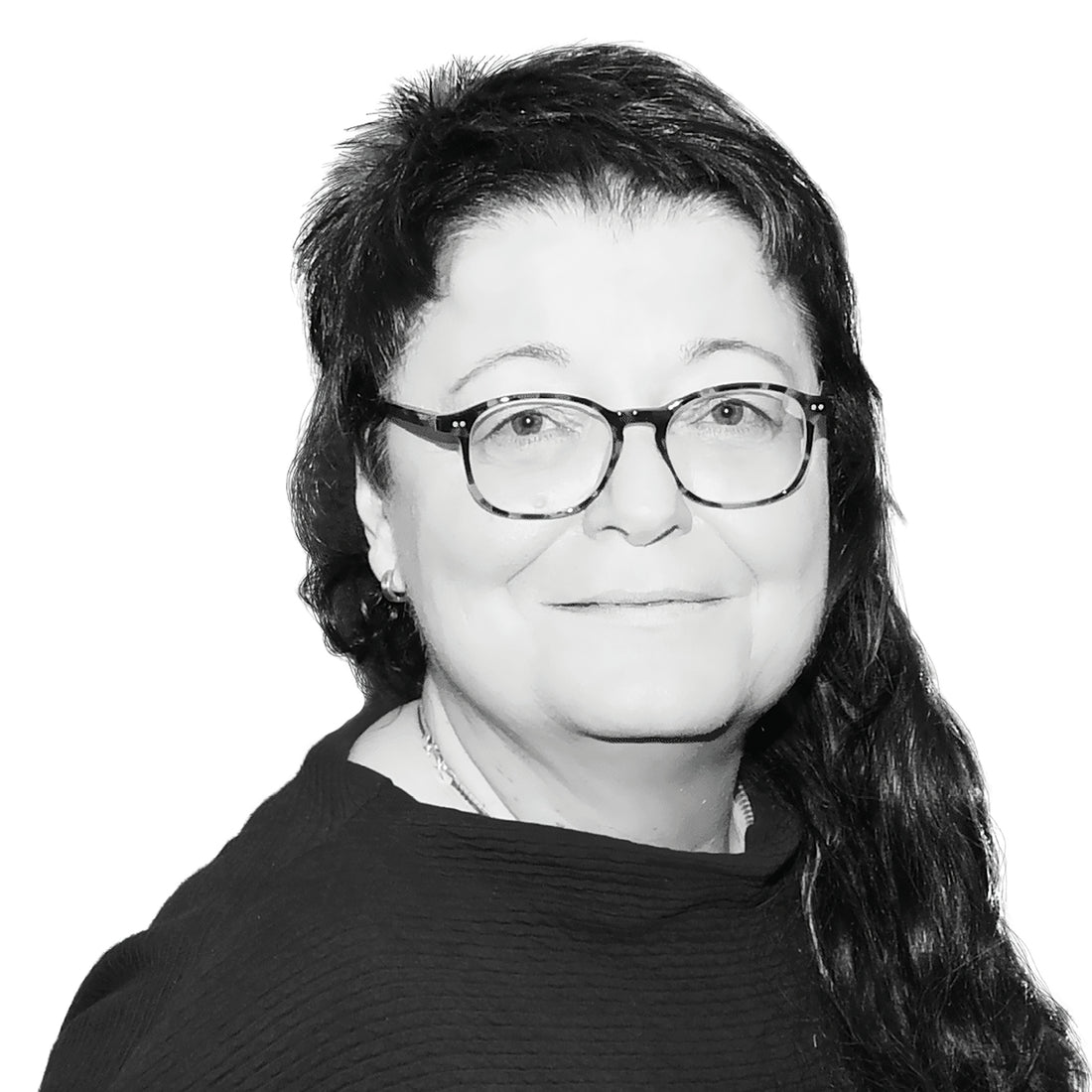 Frau mit Brille und langen dunklen Haaren, lächelnd, in einem dunklen Oberteil, auf weißem Hintergrund.