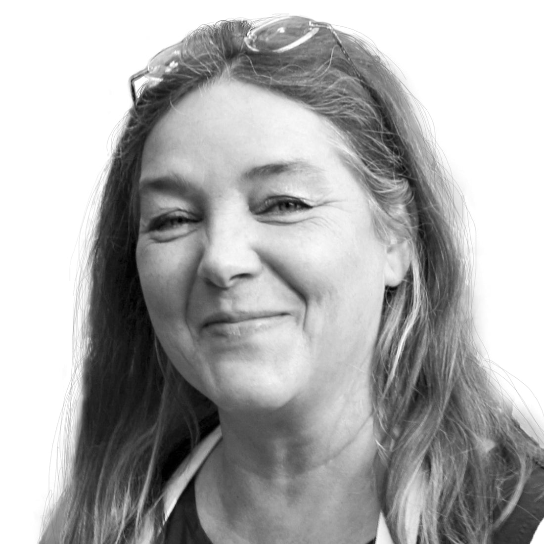 Lächelnde Frau mit langen Haaren, einer Brille auf dem Kopf und einem weißen Band um den Hals auf weißem Hintergrund.