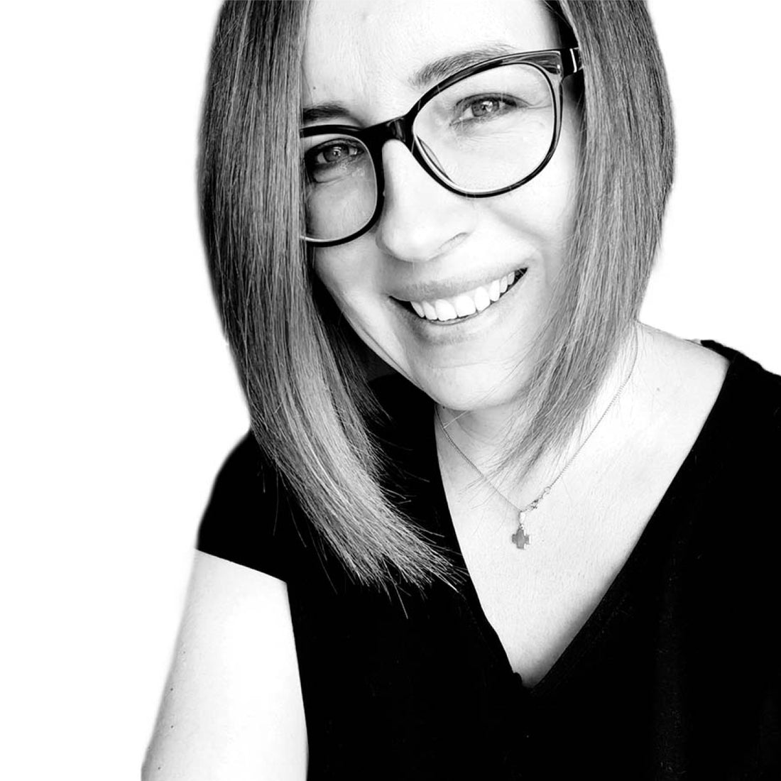 Frau mit glattem, schulterlangem Haar und Brille, lächelt in die Kamera, trägt ein schwarzes Oberteil.