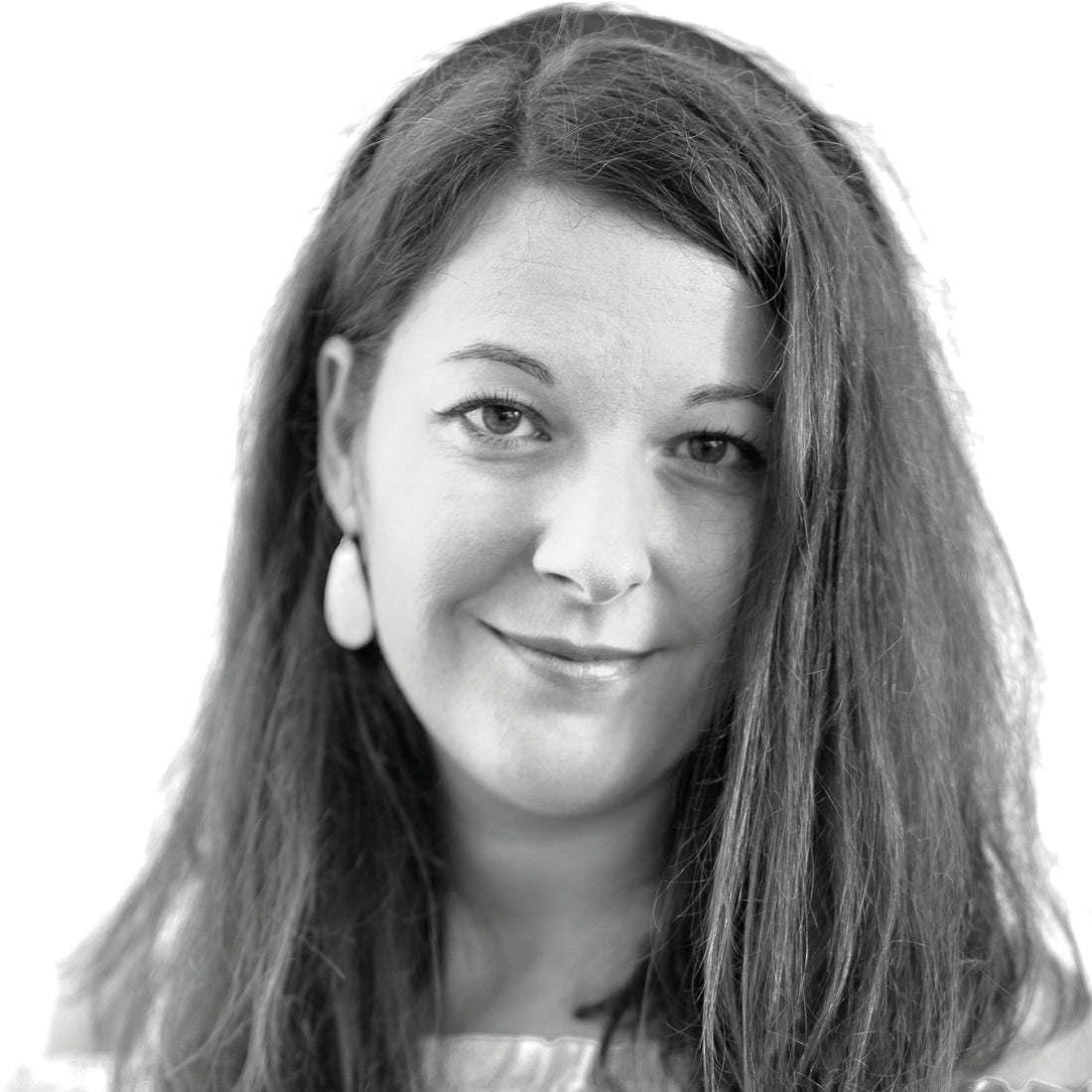 Frau mit langen Haaren, die Ohrringe trägt und sanft in die Kamera lächelt, in einem Schwarz-Weiß-Porträt.