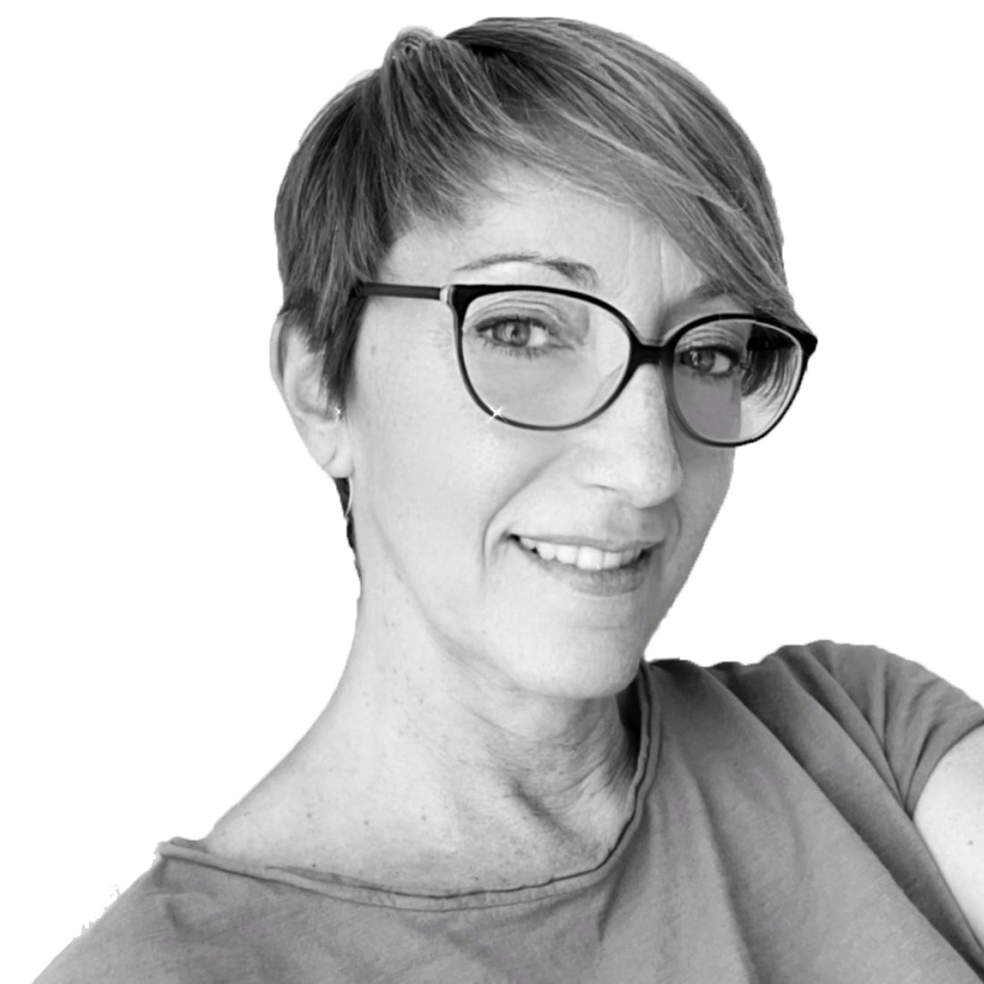 Lächelnde Frau mit kurzen Haaren und Brille, die ein T-Shirt trägt, in einem Schwarz-Weiß-Porträt.