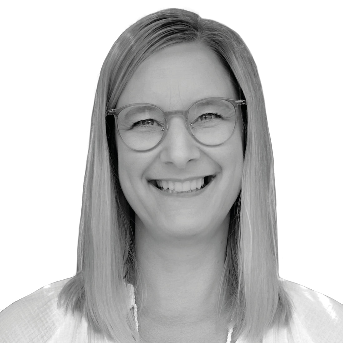 Lächelnde Frau mit glattem blondem Haar und Brille, die ein helles Oberteil trägt, auf weißem Hintergrund.