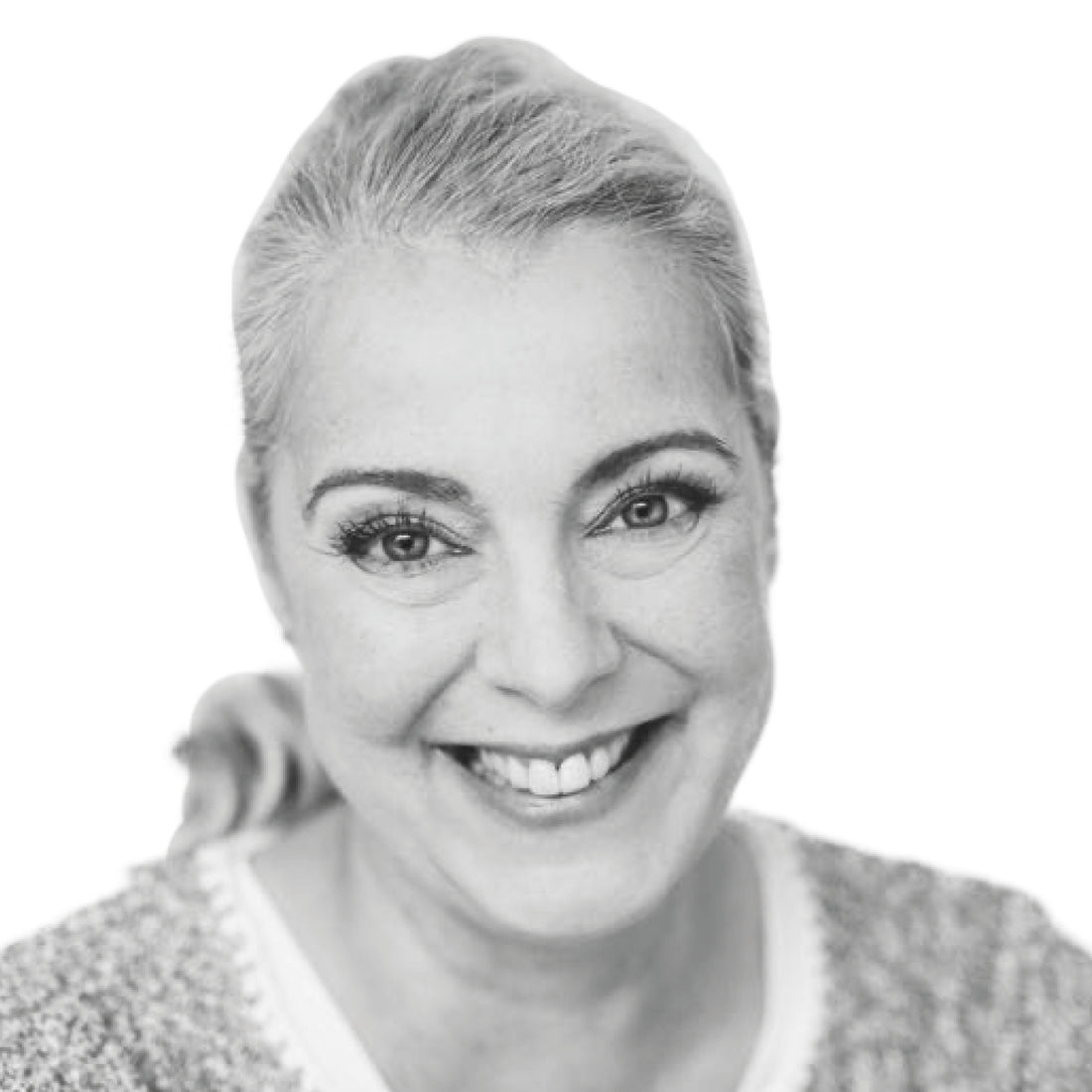 Lächelnde Frau mit hellen, nach hinten gezogenen Haaren, die einen Pullover trägt, fotografiert vor einem weißen Hintergrund.