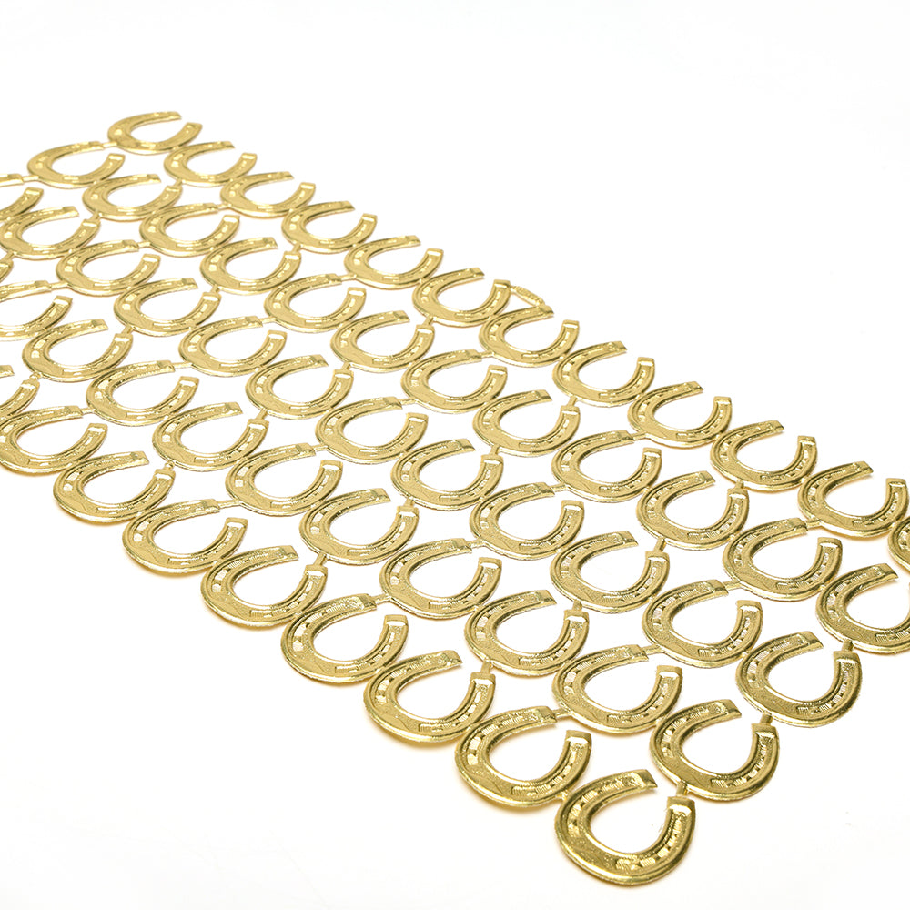 Dutzende von goldenen Hufeisen aus ☆ sind in ordentlichen Reihen auf weißem Hintergrund angeordnet und bilden elegante Dekoelemente, die an Papierarbeit oder zarte Figurinen erinnern.