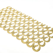 Dutzende von goldenen Hufeisen aus ☆ sind in ordentlichen Reihen auf weißem Hintergrund angeordnet und bilden elegante Dekoelemente, die an Papierarbeit oder zarte Figurinen erinnern.