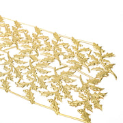 Goldene Stechpalmenblatt- und Beerengirlande von ☆, diagonal auf weißem Hintergrund angeordnet - ideal als Dekoelemente für Ihren Festtagstisch oder zur Akzentuierung von Papierarbeiten und Figurinen.