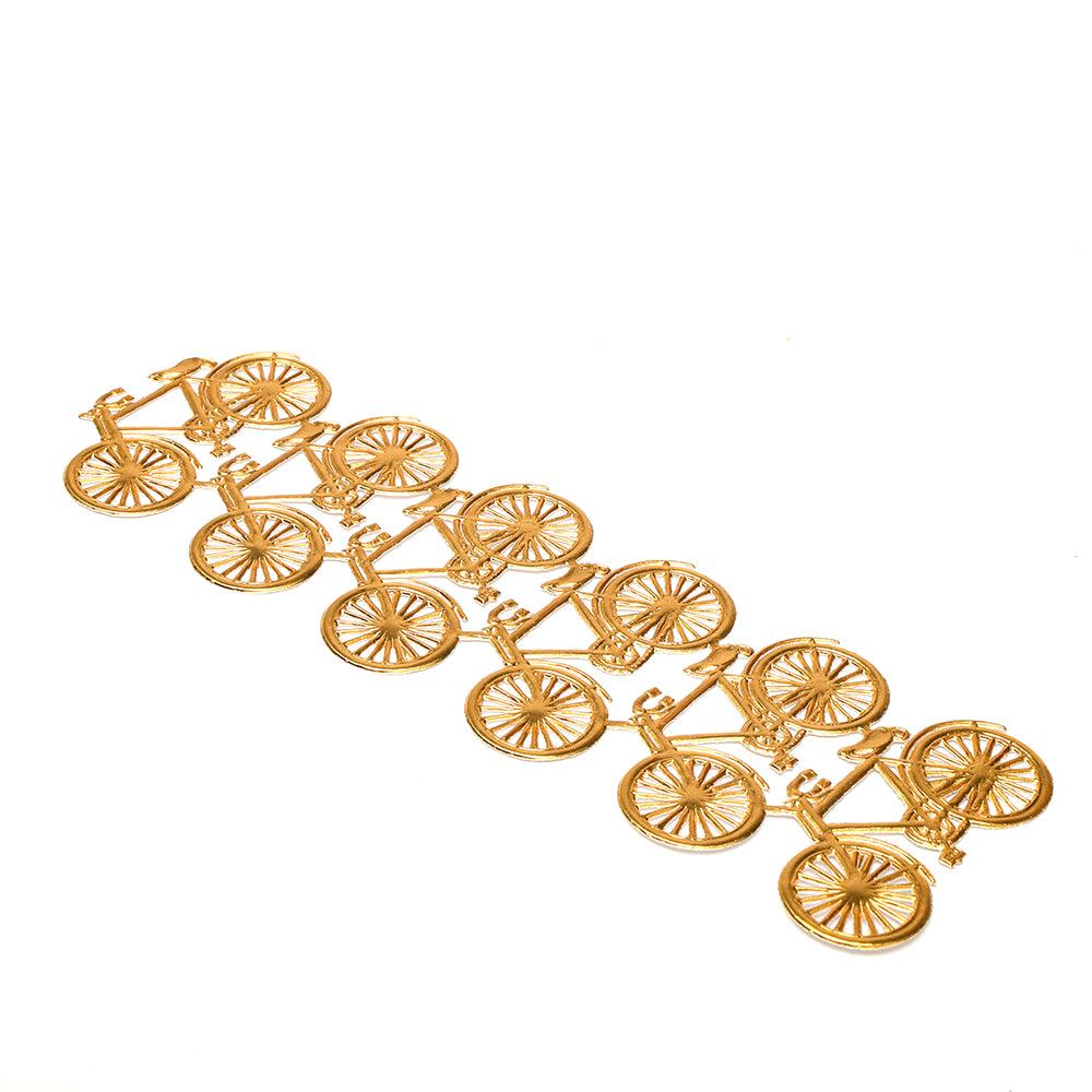 Diagonal angeordnete goldene Fahrradfiguren auf weißem Hintergrund - elegante Dekorationselemente, ideal für Ihre Bastel- oder Dekorationsprojekte.