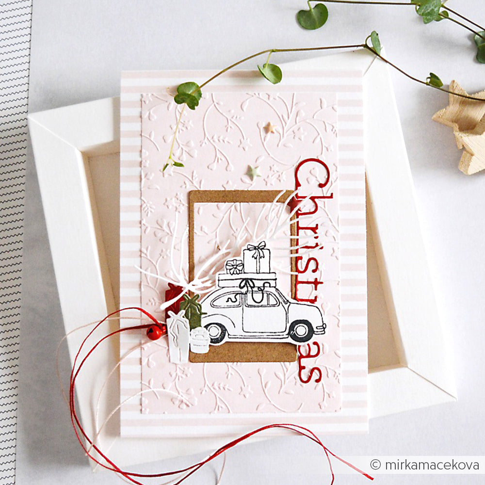 Handgefertigte Weihnachtskarte von Alexandra Renke mit einem Auto mit Geschenken, rotem Weihnachtstext und festlichen Dekorationen, die mit einem Cut & Emboss Folder für strukturierte Details bearbeitet wurden.