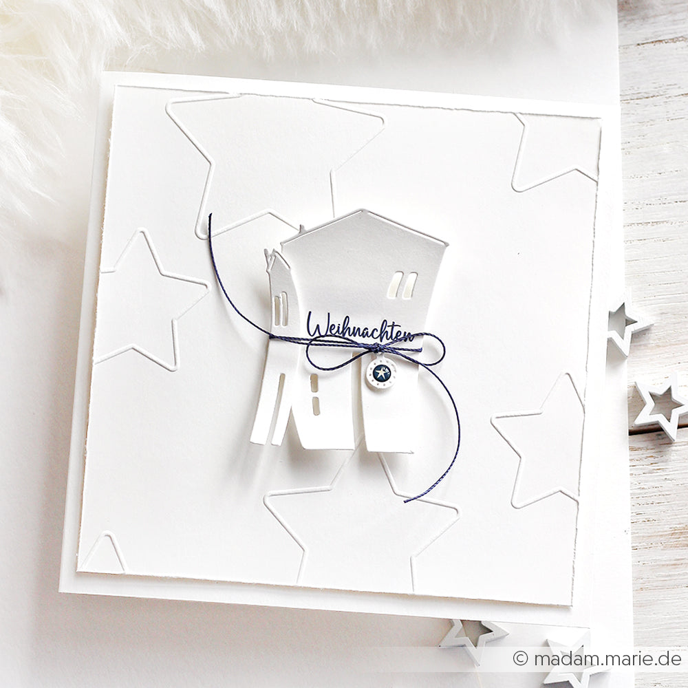 Weiße Weihnachtskarte von Alexandra Renke mit Sterne Outline-Sternmustern, einem mit Schnur gebundenen Papierhaus und dem Text "Weihnachten", der mit einem Embossing-Folder plastisch gestaltet wurde.