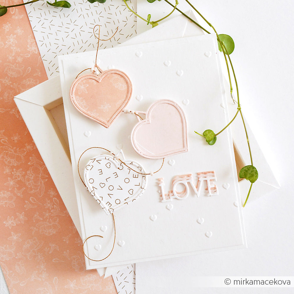 Handgefertigte Karte von Alexandra Renke mit drei Herzchenregen-Motiven, dem Text "LOVE" und einer Blattranke auf weißem Grund, die mit Embossing Folder-Techniken für zusätzliche Textur bearbeitet wurde.