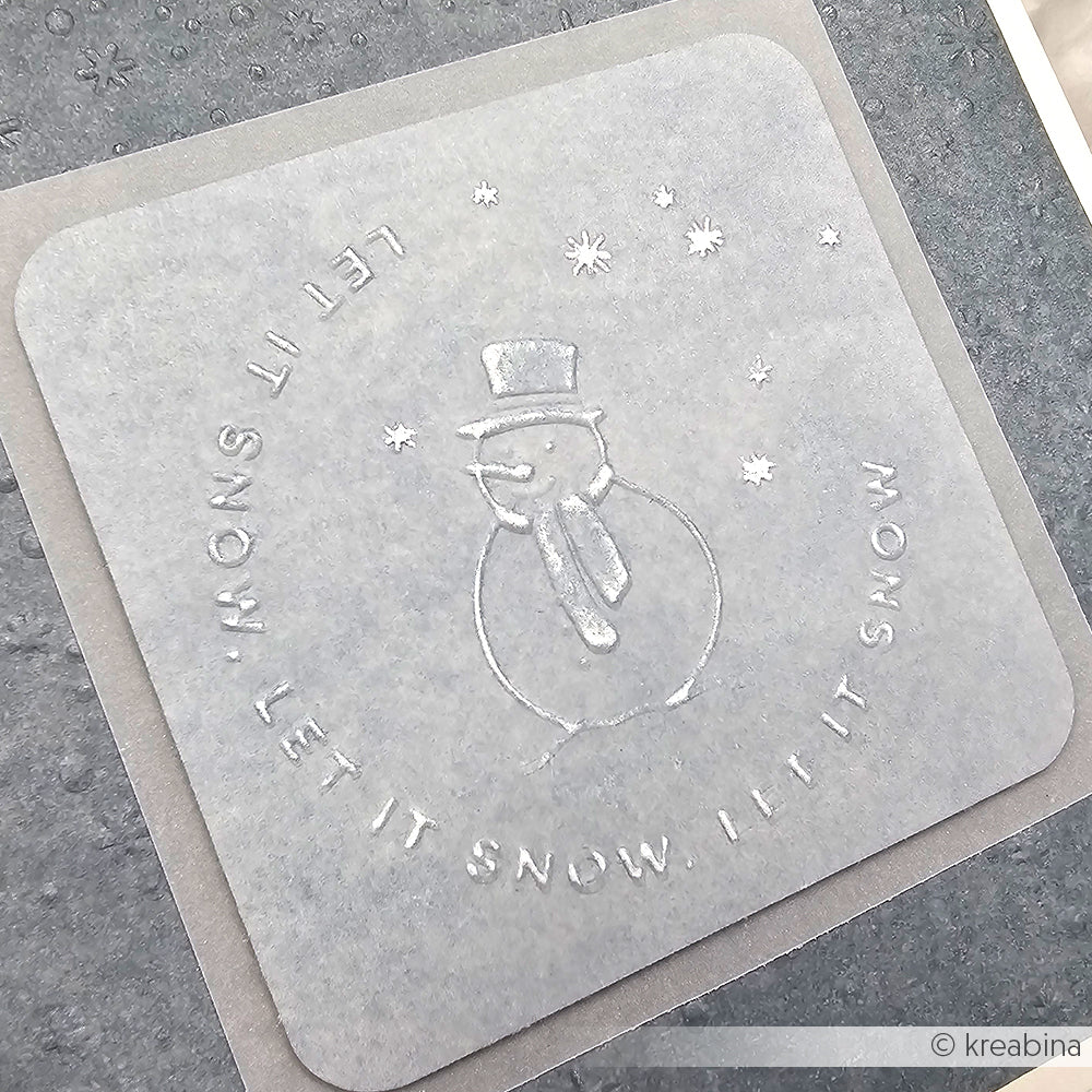 Alexandra Renke Cut & Emboss Folder erstellt einen geprägten Schneemann mit dem Text "Let it Snow!" und Schneeflocken auf einem quadratischen, durchscheinenden Bogen.