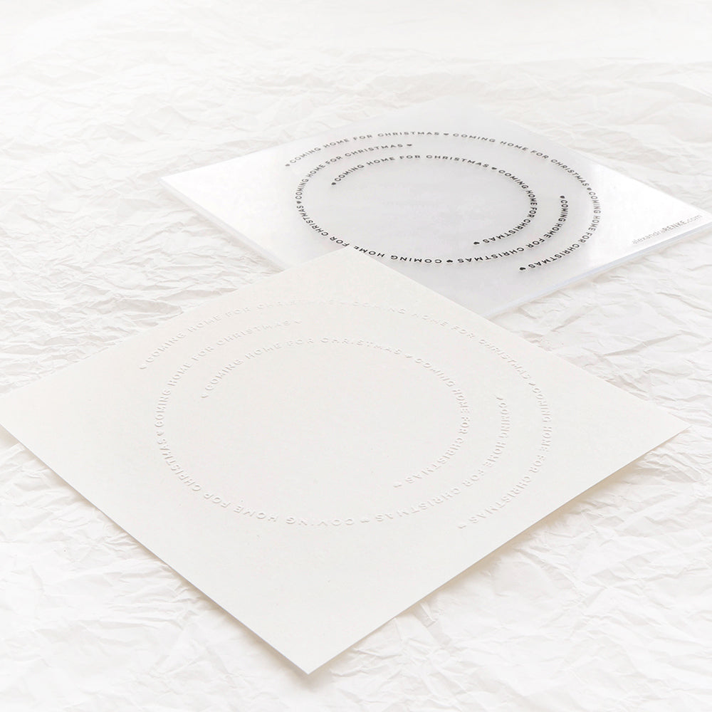 Zwei quadratische Bögen mit kreisförmigen, minimalen Textmotiven auf zerknittertem weißem Papier - ideal, um Alexandra Renke Produkte hervorzuheben oder mit einem Prägefolder zu kombinieren.