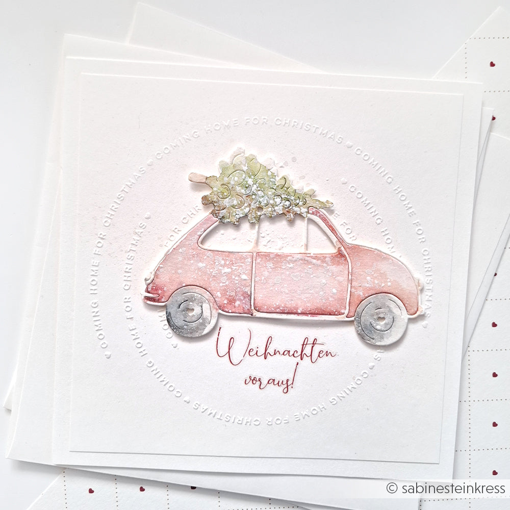 Illustration eines rosafarbenen Autos, das einen Weihnachtsbaum trägt, mit "Weihnachten voraus!" darunter - perfekt für Alexandra Renke Coming Home for Christmas-Karten oder zur Verwendung mit einem Cut & Emboss Folder.