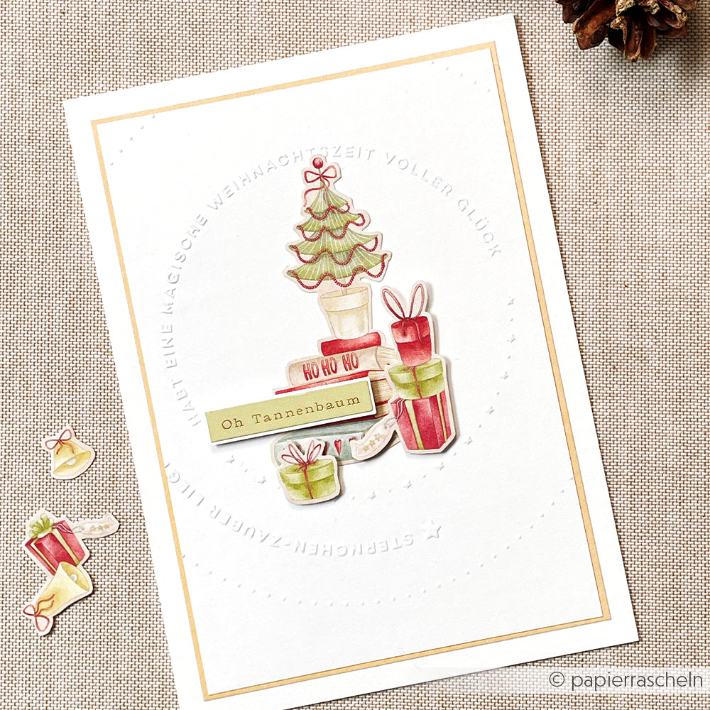 Handgefertigte Weihnachtskarte von Alexandra Renke mit einem geschmückten Baum, Geschenken und deutschen Weihnachtsgrüßen in sanften Farben, bearbeitet mit einem Prägefolder für strukturierte Details.