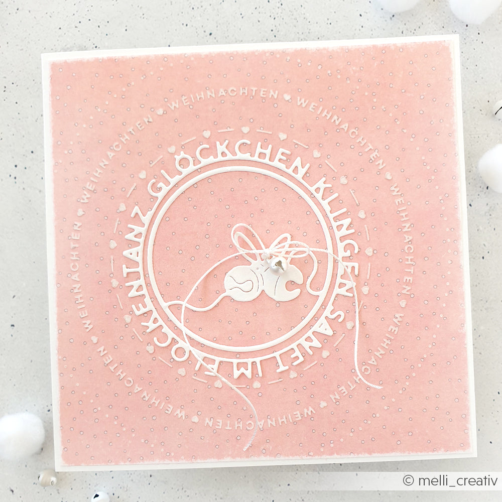 Quadratische, rosafarbene Weihnachtskarte von Alexandra Renke mit weißem Text und zwei Glocken, die mit einer Schnur in der Mitte zusammengebunden sind. Sie wurde mit dem Embossing Folder Weihnachten für einen festlichen, strukturierten Look gestaltet.