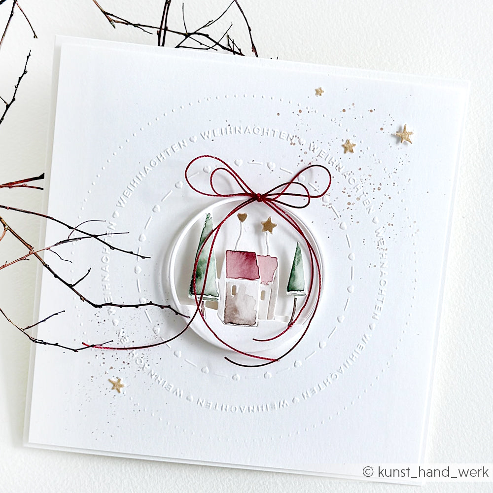 Minimalistische Weihnachtskarte mit einem Haus, Bäumen und Sternen auf weißem Grund, gebunden mit einer roten Schleife aus Kordel. Mit dem Alexandra Renke Prägefolder Weihnachten für zusätzliche Struktur.