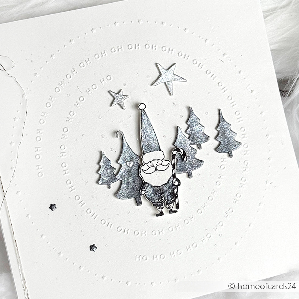 Handgemachte Karte von Alexandra Renke mit einem silbernen Gnom, Bäumen und Sternen auf weißem Hintergrund, hergestellt mit dem Cut & Emboss Folder und geprägten Kreisen von Typo Kreis Ho Ho Ho.