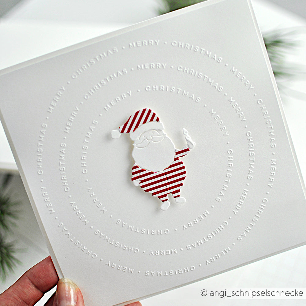 Weiße Karte mit einem rot gestreiften Weihnachtsmann und einer geprägten "Merry Christmas"-Spirale, hergestellt mit dem Alexandra Renke Kreis Merry Christmas Embossing Folder.