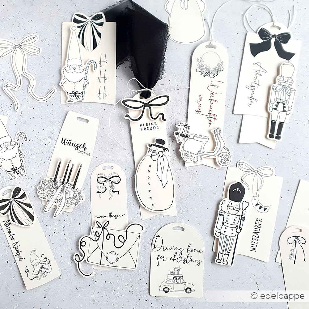Die verschiedenen schwarz-weißen Weihnachtsgeschenkanhänger von Alexandra Renke sind mit festlichen Zeichnungen, Schleifen, handgeschriebenen Botschaften und charmanten Ephemera versehen und verleihen dem Fest eine besondere Note.